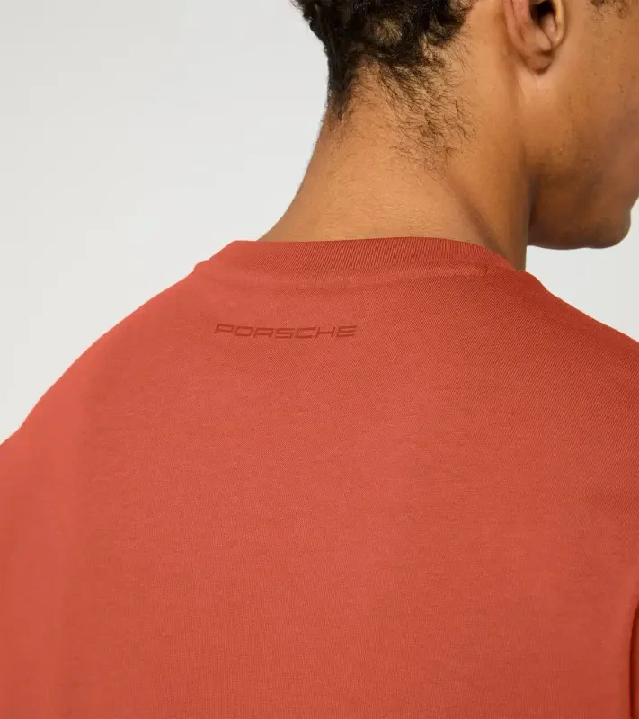 Porsche Race Americana T-Shirt Lifestyle Porsche Legacy x PUMA Tričko volnočasové s výstřihem ke krku bavlněné s reliéfním nápisem lávově oranžová