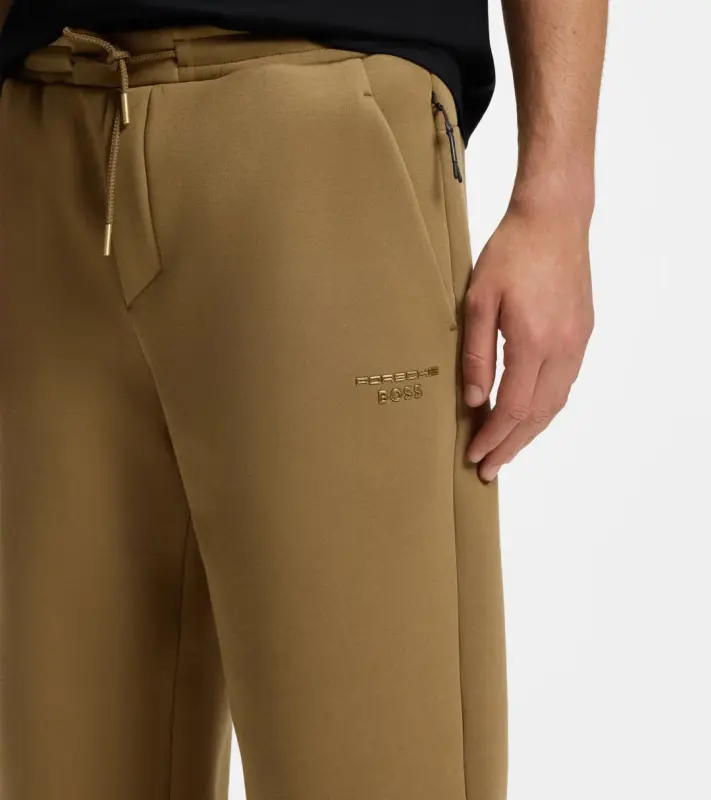 PORSCHE DESIGN Stretch-Jersey Tracksuit Bottoms with logo Porsche x BOSS  Kalhoty volnočasové sportovní mírně strečové s náplety v hnědé camelce