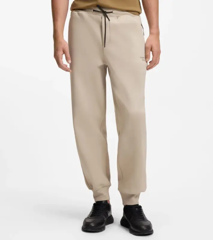 PORSCHE DESIGN Stretch-Jersey Tracksuit Bottoms with logo Porsche x BOSS Kalhoty volnočasové sportovní mírně strečové s náplety v béžové